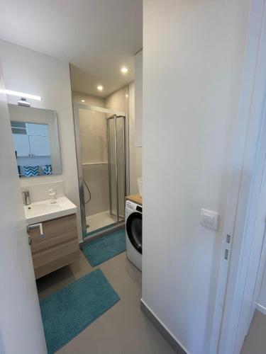 une salle de bain avec un lavabo et une machine à laver dans l'établissement BLUE COCOON Studio 27m2 VILLEJUST, à Villejust