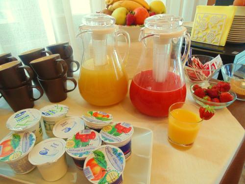 a table with two containers of juice and cups of fruit at Villa Emma Malcesine in Malcesine