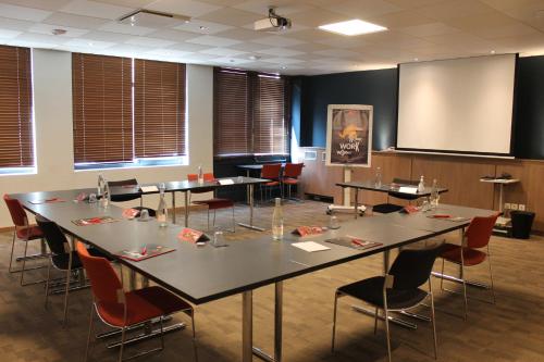 a conference room with tables and chairs and a screen at ibis Lyon Centre Perrache in Lyon