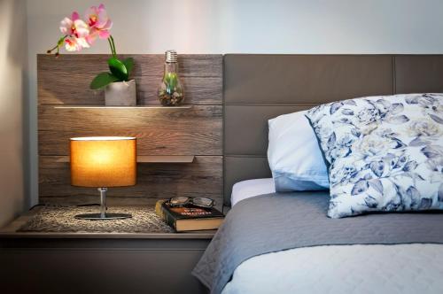 1 dormitorio con 1 cama con lámpara en una mesa en Apartment & Rooms Graciela, en Rovinj