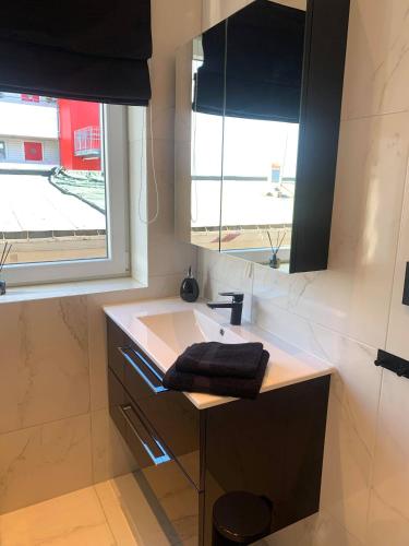 a bathroom with a sink and a window at Notodden Sentrum Apartment NO 6 in Notodden