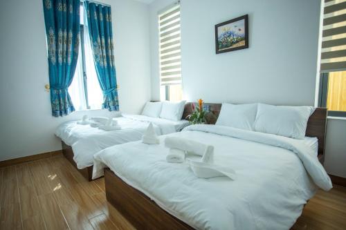 three beds in a room with blue walls at Win Villa Coffee in Da Lat