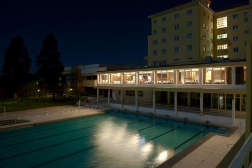 a swimming pool in front of a building at night at Grande Hotel De Luso in Luso
