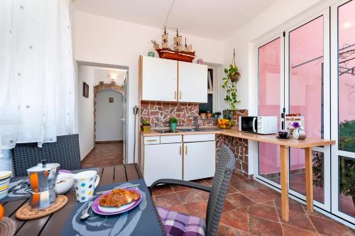 a kitchen with a table with a plate of food on it at Apartment & Rooms Graciela in Rovinj