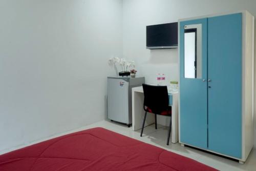 a room with a red rug and a table and a blue door at D'Paragon Kijang Utara in Alastuwo