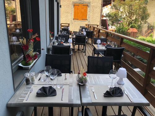 a restaurant with tables and chairs on a balcony at Hotel L'alpin in Landry