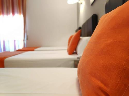 a row of beds in a hotel room at Hotel Perú by Bossh! Hotels in Trujillo