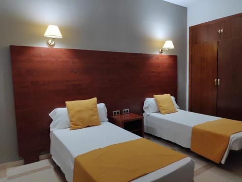 a hotel room with two beds with yellow pillows at Hotel Perú by Bossh! Hotels in Trujillo