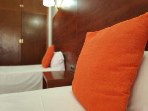 an orange pillow sitting on a bed in a room at Hotel Perú by Bossh! Hotels in Trujillo
