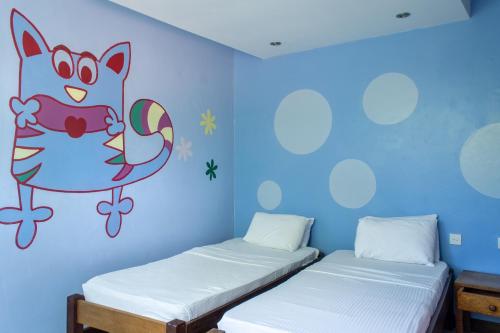 a room with two beds and a painting of a fox at Cowrie Shell Beach Apartments Official in Bamburi