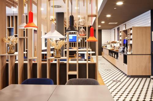 a restaurant with a long table and chairs at Holiday Inn Express Munich - Olympiapark by IHG in Munich