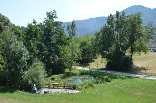 a person sitting on a bench next to a river at Tourist farm Mulej in Bled