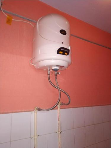 une lumière blanche sur le mur d'une salle de bains. dans l'établissement Meera Lodge, à Chidambaram