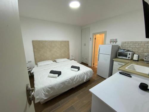 1 dormitorio con 1 cama y cocina con nevera en צפים על הים, en Neve Zohar