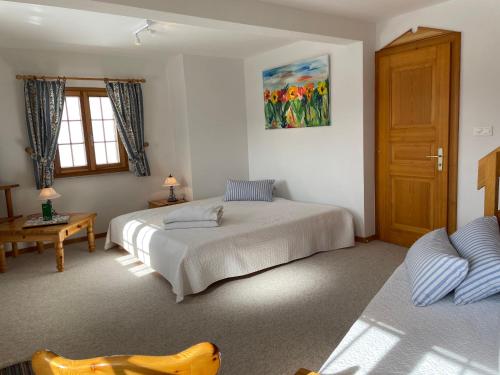 a bedroom with two beds and a wooden door at Chalet Michele Alpage in Les Collons