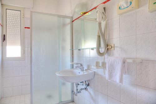 y baño blanco con lavabo y ducha. en Hotel Panama, en Lido di Jesolo