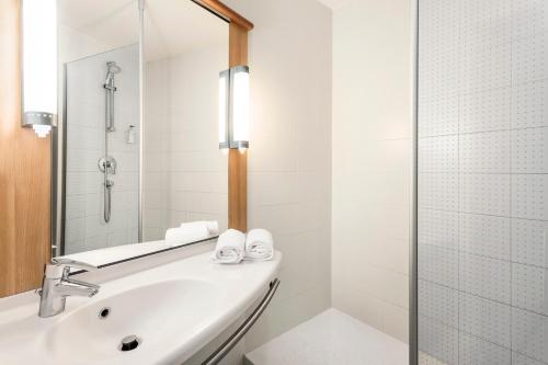 a bathroom with a large mirror and a tub at B&B Hotel Barcelona Mataro in Mataró