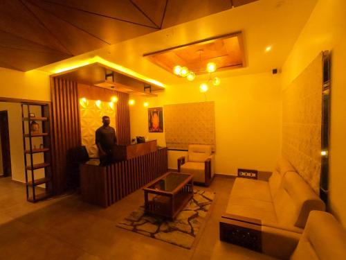 a man standing at a desk in a living room at The Wild Trails Clarks Exotica , Munnar in Munnar