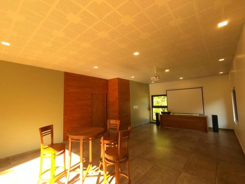 a room with a table and chairs and a screen at The Wild Trails Clarks Exotica , Munnar in Munnar