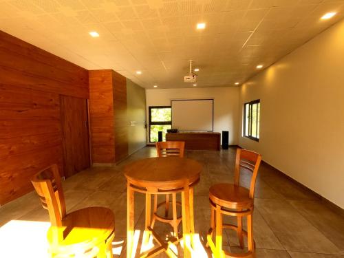a conference room with a table and chairs and a screen at The Wild Trails Clarks Exotica , Munnar in Munnar