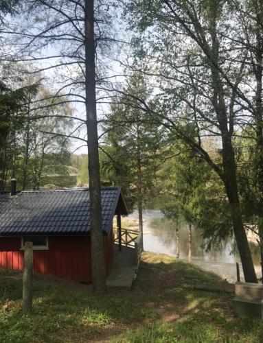 une cabine rouge dans les bois à côté d'une rivière dans l'établissement Nye hytta,Holmfoss/Kvelde, à Larvik