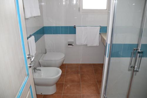a bathroom with a toilet, sink, and shower at Hotel Baia Marina in Orosei