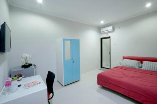 a bedroom with a red bed and a blue door at D'Paragon Bukit Sari in Semarang