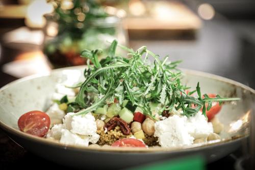 a salad in a bowl on a table at Revier Mountain Lodge Lenzerheide in Lenzerheide