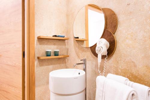 a bathroom with a sink and a mirror at Laqua by the Sea in Meta