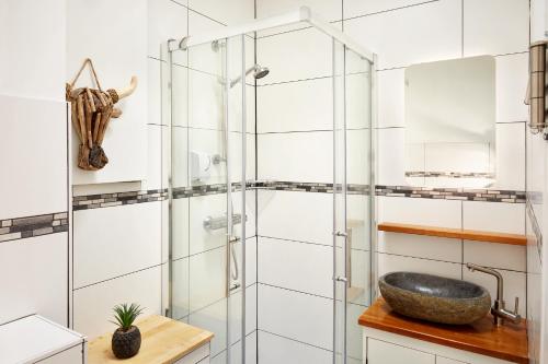 a bathroom with a glass shower and a sink at Guest House Aquarius in Zandvoort