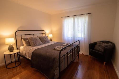 a bedroom with a bed and a chair and a window at The Chichester Retreat in Bandon Grove