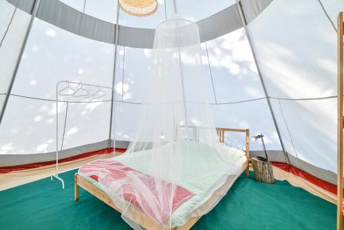 a bed in a room with a large window at Salema Eco Camp - Sustainable Camping & Glamping in Salema