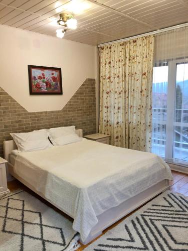 a bedroom with a large bed and a window at Karpatska Mria in Yaremche