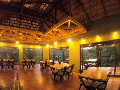 a dining room with wooden tables and chairs at The Wild Trails Clarks Exotica , Munnar in Munnar