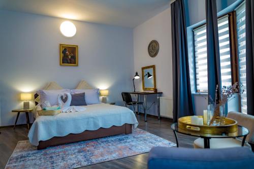 a bedroom with a bed and a table in a room at Villa Casafina Serviced Apartments in Mangalia