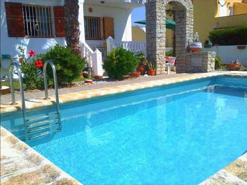 una gran piscina azul frente a una casa en Villa Secreto, en Peñíscola