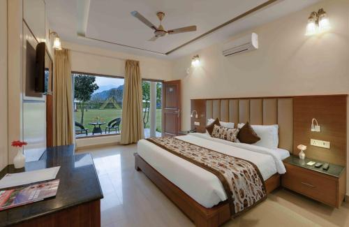 a bedroom with a large bed and a large window at Excel Hotels and Resorts Bhimtal in Bhīm Tāl