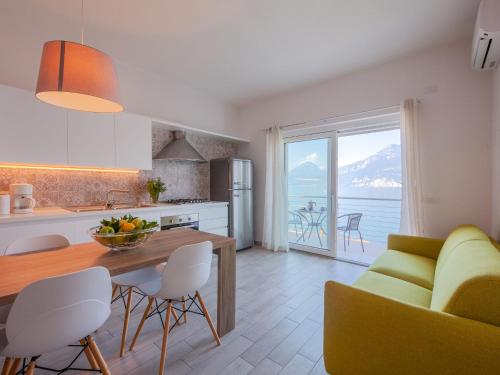 a kitchen and living room with a table and chairs and a view at Apartment La Maison Blanche-2 by Interhome in Brenzone sul Garda