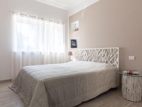 a white bedroom with a large bed and a window at Apartment La Maison Blanche-2 by Interhome in Brenzone sul Garda