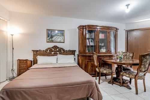 ローマにあるBravetta House Pamphiliのベッドルーム1室(ベッド1台、テーブル、椅子付)