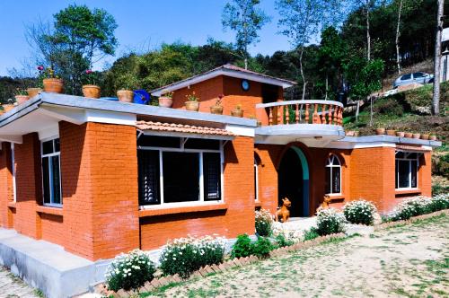 a brick house with a dog in front of it at Hotel Mount Paradise in Nagarkot