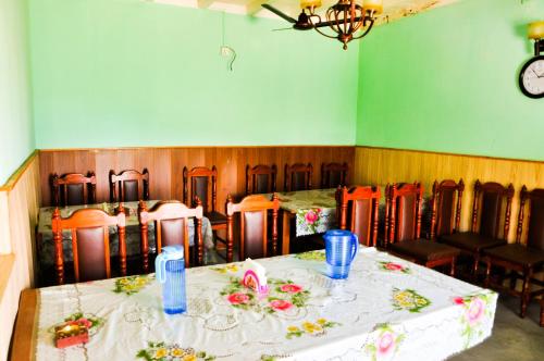 uma sala de jantar com mesa e cadeiras e um relógio em Hotel Mount Paradise em Nagarkot