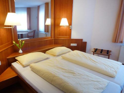 ein großes Bett mit zwei Kissen in einem Schlafzimmer in der Unterkunft Apartment Flesch-3 by Interhome in Schelingen