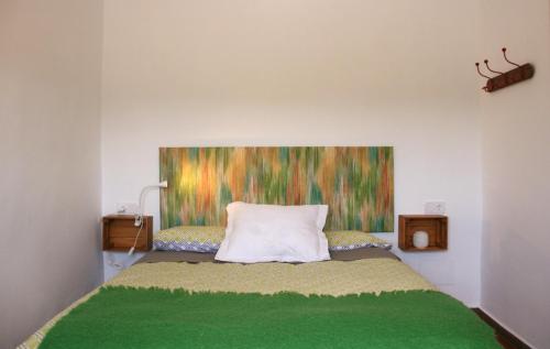 Un dormitorio con una cama con un cuadro en la pared. en CASA RURAL ENTRE VINYES, en El Pinós (Pinoso)