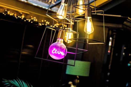 una bottiglia rosa appesa a un soffitto con luci di OYO The Townhouse a Durham