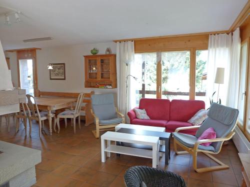 sala de estar con sofá rojo y sillas en Holiday Home Chalet Marbach by Interhome, en Faulensee