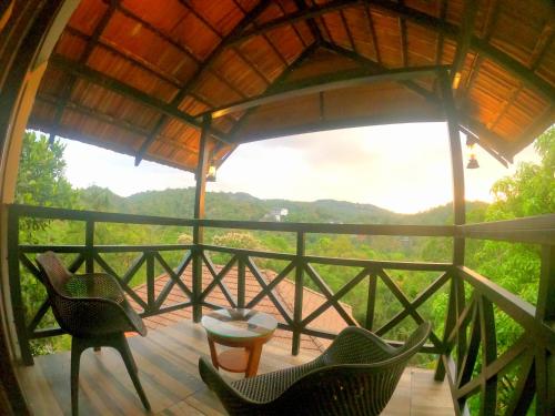 a room with a balcony with chairs and a table at The Wild Trails Clarks Exotica , Munnar in Munnar