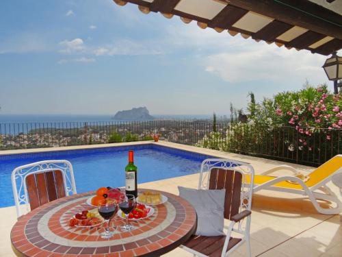 una mesa con una botella de vino junto a una piscina en Holiday Home Villa Osyris by Interhome, en Fanadix