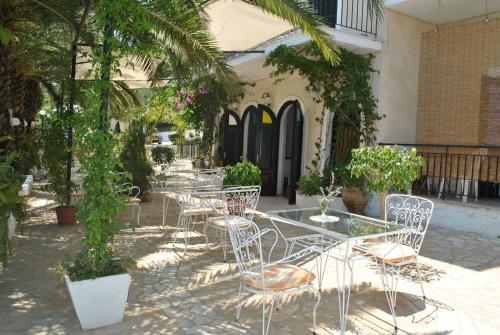 een groep tafels en stoelen voor een gebouw bij Hotel Helios Splendid in Boukari