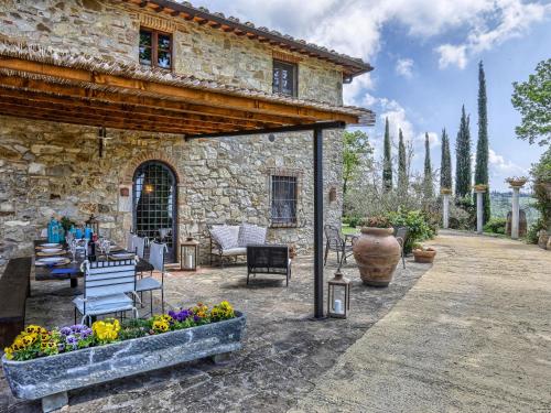 una casa de piedra con un patio con flores frente a ella en Holiday Home Casale Il Poggino by Interhome, en Fonterutoli